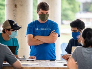 Photo of Instructor Ben Cooke teaches students in Engineering 101 in a classroom setup outside