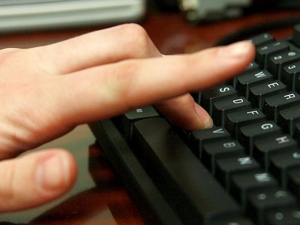 Image of hand typing on keyboard
