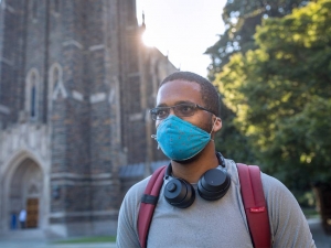 Photo of student wearing a mask walking pass Duke Chapel Couresty of University Communications