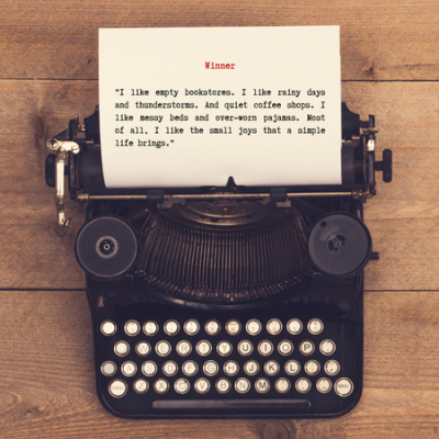Image of antique typewriter and piece of paper on a wooden desk